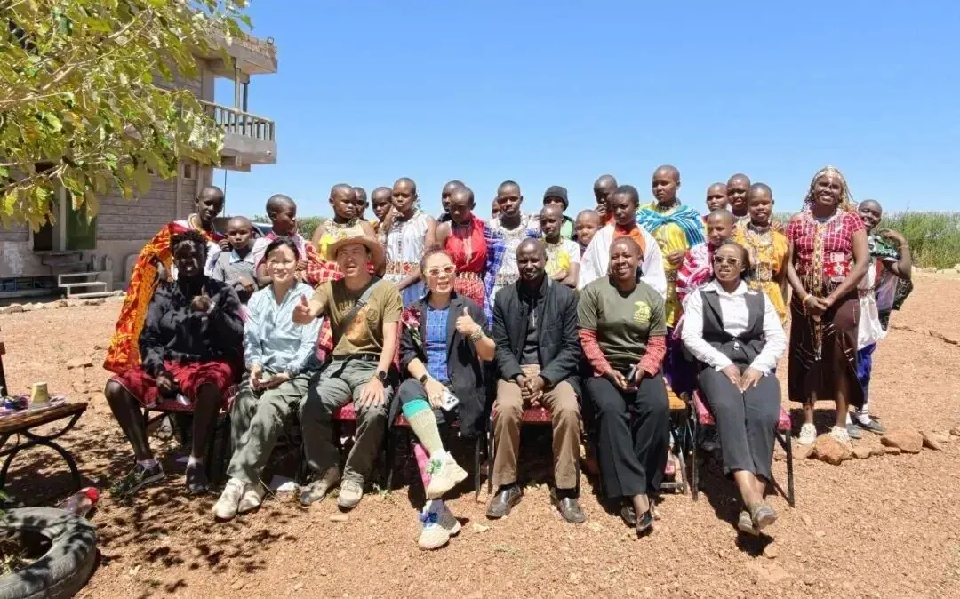 Community members, children and guests gathered under the tree